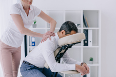 Homme assis en costume recevant un massage